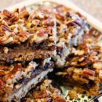 chocolate pecan bars stacked on top of a plate