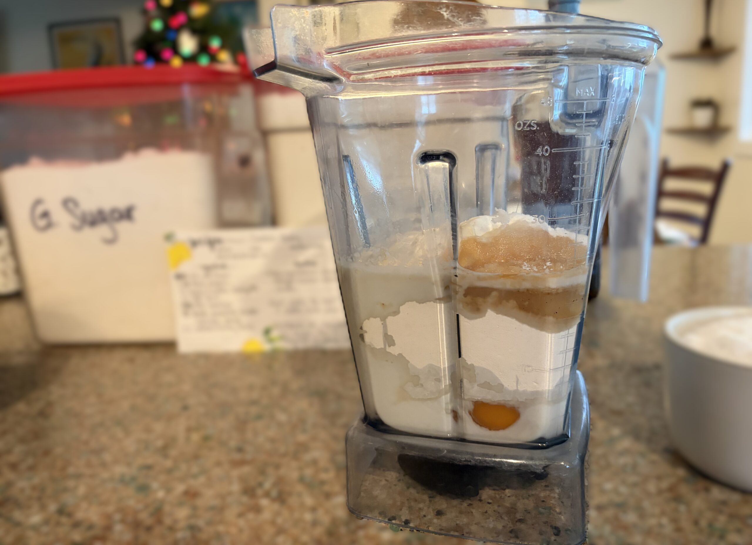 Vitamix blender with dutch baby wet and dry ingredients layered.